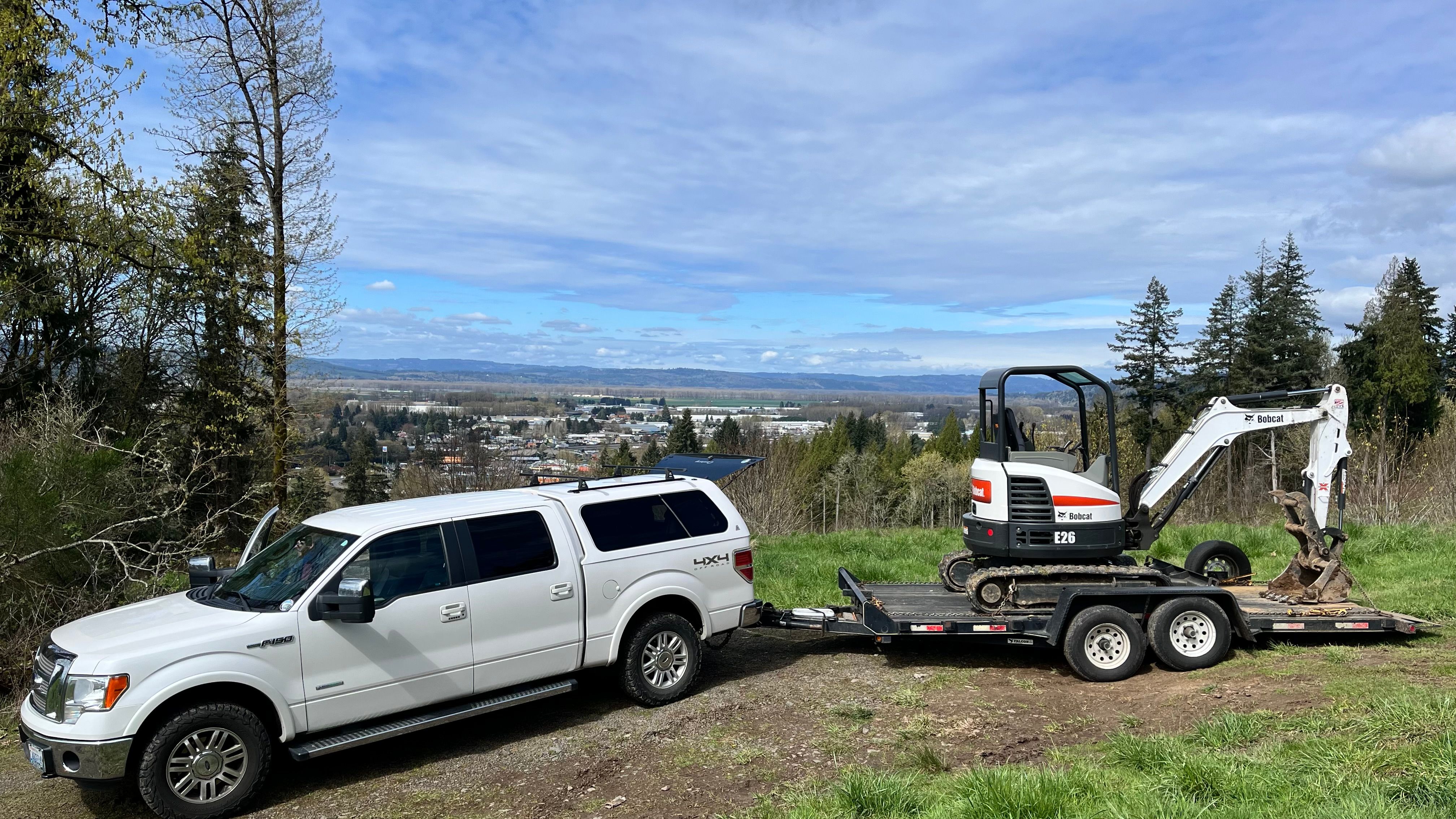 EGSD truck and Bobcat excavator on trailer at a job site
